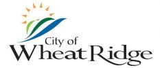 Logo with a sun over blue lines and text that reads City of Wheat Ridge