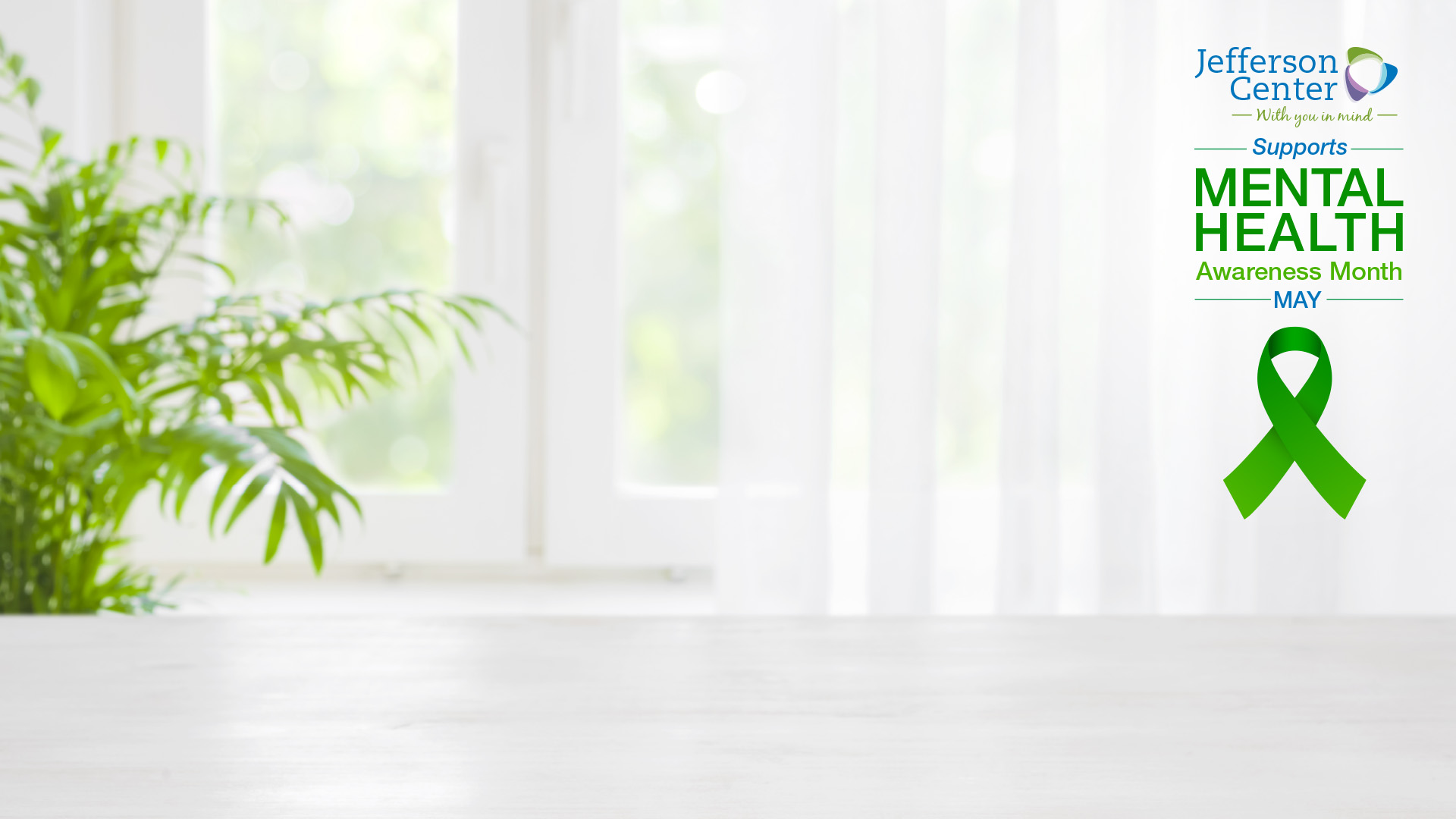 A digital background for virtual meetings. The background image is a soft-focus photo of a bright room with a plant and a window. On the right side is a graphic that reads, "Supports Mental Health Awareness Month - MAY -" above a green awareness ribbon.