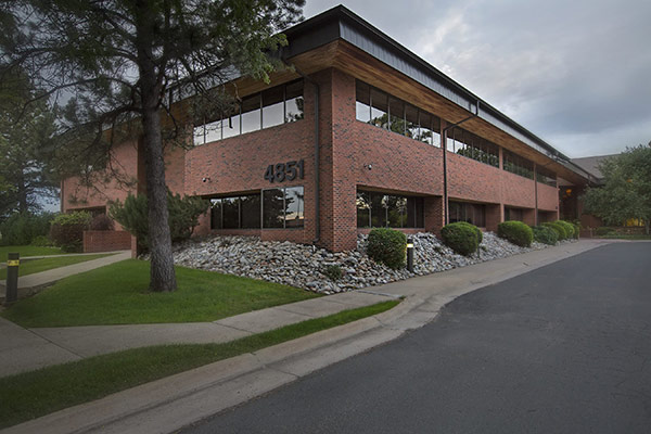 The exterior of a two-story, red brick office building at the address 4851 Independence St. Wheat Ridge, CO