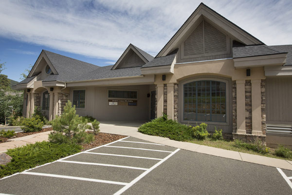 The exterior of a single-story, mountain-style office building in Evergreen, with the address 31207 Keats Way.