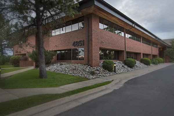 The exterior of a two-story, red brick office building at the address 4851 Independence St. Wheat Ridge, CO